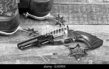 Alten westlichen Pistole, Abzeichen, Sporen und Cowboy-Stiefel in schwarz und weiß. Stockfoto