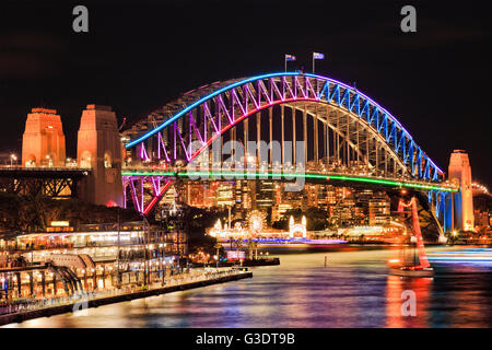 Hell beleuchtete Bogen Seite Wahrzeichen Sydney Harbour Bridge nach Sonnenuntergang reflektierenden Lichter in unscharfen stillen Wassern der Bucht. Stockfoto