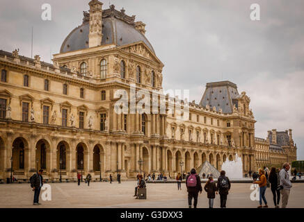 Touristen flanieren rund um den Hof an den Louvre mit eines der Louvre Gebäude als Kulisse Stockfoto