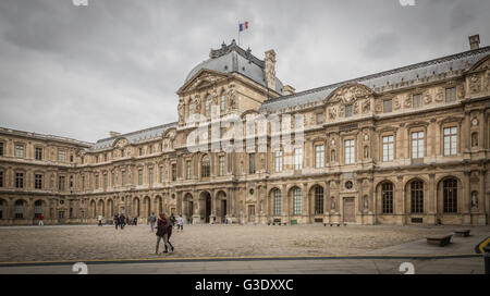 Touristen Flanieren im Innenhof dem Louvre, einst ein königlicher Palast und jetzt ein Museum in Paris und eine wichtige touristische Attraktion. Stockfoto