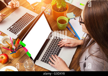 Junge Frau mit Laptop am Schreibtisch aus Holz mit leeren Bildschirm für Text platziert. Schuss aus Vogelperspektive Stockfoto