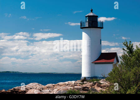 Annisquam Leuchtturm an der Felsenküste an einem sonnigen Tag mit Wolken in Gloucester, Massachusetts. Stockfoto