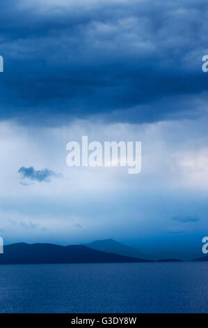 Seelandschaft mit fernen Berge und düsteren Himmel Stockfoto