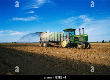 Landwirtschaft - ein Traktor und Tank Spreader verteilt Gülle auf ein Feld Mais Stoppeln für Dünger / McHenry County, Illinois, USA. Stockfoto