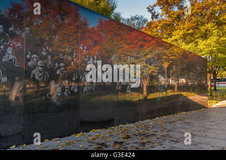 Fotografische Bilder von Soldaten und herbstlichen Bäumen spiegeln sich in der hochpolierten schwarzen Granitwand des Koreanischen Kriegsdenkmals in Washington DC wider Stockfoto