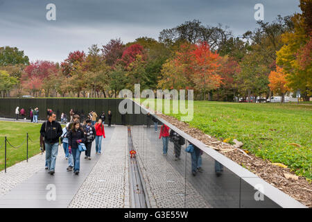 Besucher des Vietnam Veterans Memorial, wo die Namen der Toten des Vietnamkrieges auf der schwarzen Granitwand in Washington DC, USA, eingeschrieben sind Stockfoto