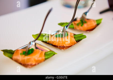 Vorspeise-Teller mit sautierten Spargel eingewickelt in dünne Scheiben geräucherter Lachs Stockfoto