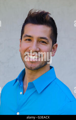 Porträt des Lächelns Hispanic Mann in blau. Kopfschuss vertikale Stockfoto