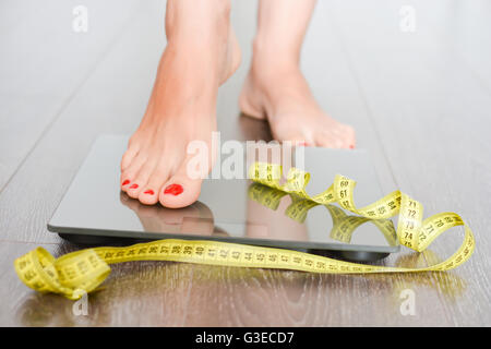 Gewichtskonzept mit Person auf einer Skala messen Kilogramm zu verlieren Stockfoto