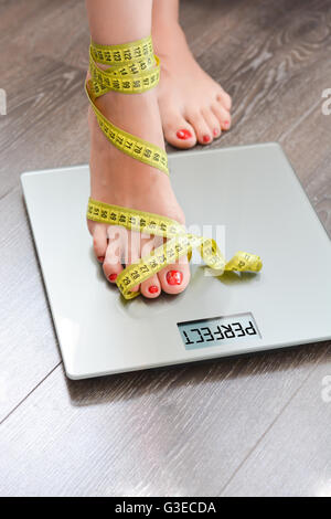Gewichtskonzept mit Person auf einer Skala messen Kilogramm zu verlieren Stockfoto