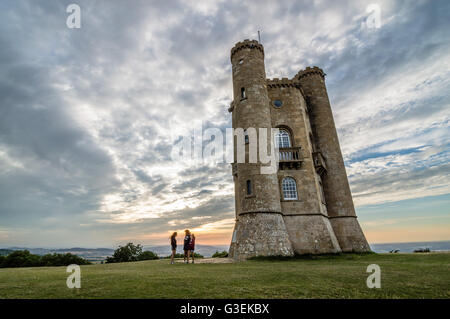 Broadway, UK - 12. August 2015: Broadway Tower mit den Silhouetten von Touristen bei Sonnenuntergang. Es wurde im 18. Jahrhundert gebaut. Stockfoto