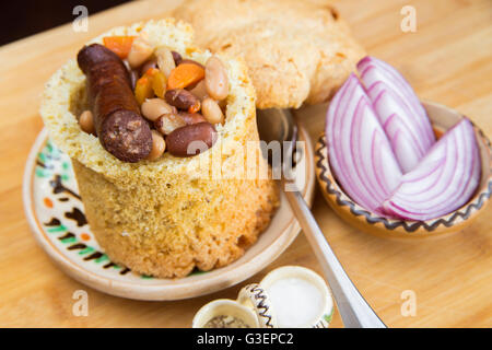 Rumänische traditionelle Bohnensuppe mit Schweinefleisch in Brot Stockfoto