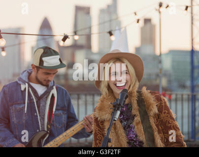 Musiker, Gitarre spielen und singen auf Party auf dem Dach Stockfoto