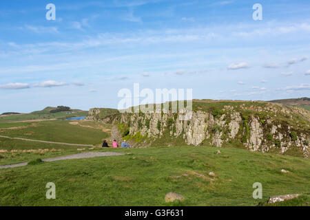 Touristen, die gerade Stahl Rigg, Hadrians Wall in der Nähe von Crag Lough, Nationalpark Northumberland, England Stockfoto