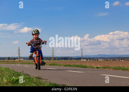 Kleiner Junge mit dem Fahrrad zum ersten Mal. Stockfoto