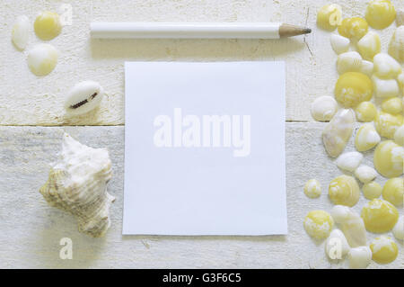 Ein Stift bereit, Notizen auf einem weißen Holztisch mit einige Muscheln verziert. Leere Kopie Platz für Text Editor. Stockfoto