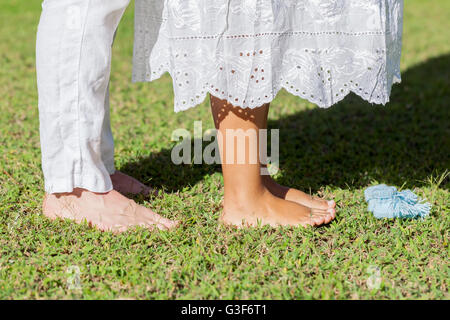 Junge schwangere paar Füße mit neugeborenen Baby Booties In der Natur Stockfoto