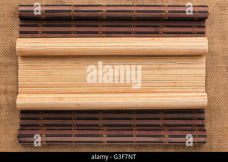 Zwei Bambusmatte verdreht in Form eines Manuskripts auf Sackleinen, mit Platz für Ihren text Stockfoto