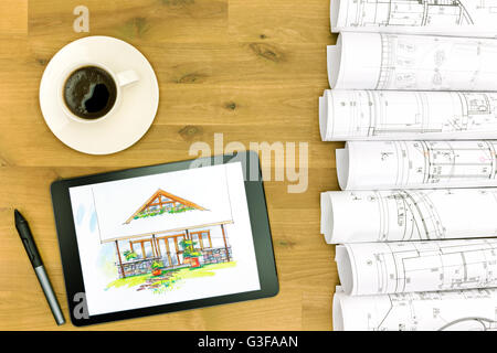 Tablet, Kaffeetasse und Architekturpläne auf Arbeitstisch Stockfoto