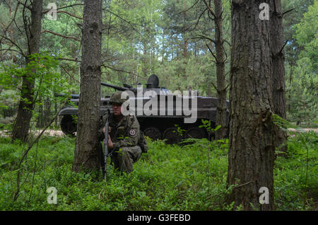 Ein polnischer Soldat hält Wache Position durch ein BWP-1 verfolgt Infanterie kämpfen Amphibienfahrzeug mit Übung Anakonda 16 9. Juni 2016 in Nowa Deba, Polen. Truppen aus 21 NATO Nationen beteiligen sich an Anakonda 2016 Übungen in Polen, das größte solche Übung seit dem kalten Krieg. Stockfoto