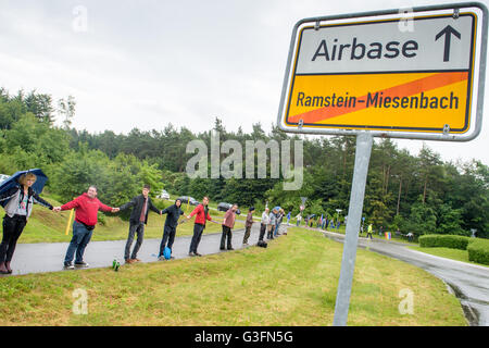 Ramstein-Miesenbach, Deutschland. 11. Juni 2016. Friedensaktivist bilden eine Menschenkette während der "Stopp-Ramstein" Kampagne in Ramstein-Miesenbach, Deutschland, 11. Juni 2016. Sie demonstrieren gegen die US-amerikanischen Luftwaffenstützpunkt und seine Rolle in den Drohnenkrieg. Foto: OLIVER DIETZE/Dpa/Alamy Live News Stockfoto