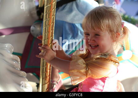 Kleines Mädchen, Kleinkind, Kind, sehr glücklich und aufgeregt auf einem Pferd auf einem Karussell in Disney's Magic Kingdom Disney World Florida Stockfoto