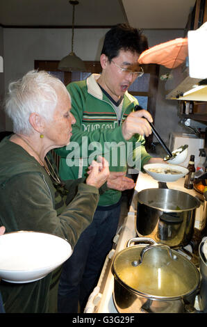 Kaukasische Frau und chinesischer Mann Alter 70 und 35 zubereiten und servieren eine St. Patricks Day-Mahlzeit. St Paul Minnesota MN USA Stockfoto