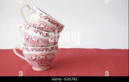 Stapel von Vintage Teetassen auf roten Tisch Stockfoto