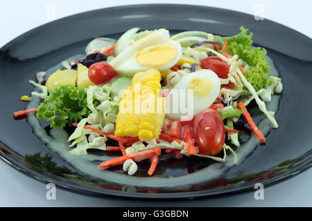 Salat mit Hühnerfleisch und Eiern auf schwarze Platte isoliert Stockfoto