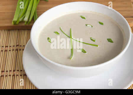 Champignon Cremesuppe und Schnittlauch auf einem Tisch Stockfoto