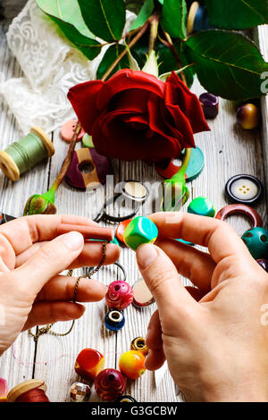 Hand bei der Herstellung von Schmuck aus Perlen und Dekor Stockfoto