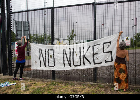 Burghfield, UK. 11. Juni 2016. Ex-Greenham Common Frieden Aktivisten hängen einen "No Nukes" Banner auf der Umzäunung des AWE Burghfield am fünften Mal in Folge Tag einer Blockade des Eingangs Lieferungen im Rahmen eines Monats gegen Trident Erneuerung bestimmt "zu blockieren, zu besetzen und zu stören" montiert die Fabrik verantwortlich für die Endmontage der Trident Atomsprengköpfe. Bildnachweis: Mark Kerrison/Alamy Live-Nachrichten Stockfoto