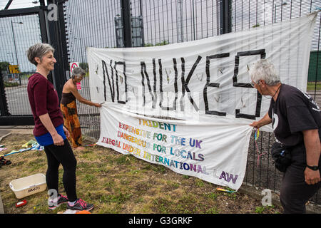 Burghfield, UK. 11. Juni 2016. Ex-Greenham Common Frieden Aktivisten hängen Banner an der Umzäunung des AWE Burghfield am fünften Mal in Folge Tag einer Blockade des Eingangs Lieferungen im Rahmen eines Monats gegen Trident Erneuerung bestimmt "zu blockieren, zu besetzen und zu stören" montiert die Fabrik verantwortlich für die Endmontage der Trident Atomsprengköpfe. Bildnachweis: Mark Kerrison/Alamy Live-Nachrichten Stockfoto