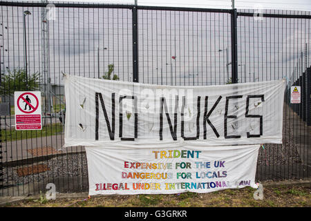 Burghfield, UK. 11. Juni 2016. Banner von Ex-Greenham Common Frieden Aktivisten an der Umzäunung an AWE Burghfield auf den fünften Tag in Folge der Blockade der Lieferungen Eingang als Teil eines Monats Klage gegen Trident Erneuerung außerhalb der Fabrik verantwortlich für die Endmontage der Trident aufgehängt montiert Atomsprengköpfe. Bildnachweis: Mark Kerrison/Alamy Live-Nachrichten Stockfoto