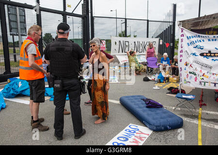 Burghfield, UK. 11. Juni 2016. Ein Verteidigungsministerium Polizist Debatten mit Frieden Aktivisten darüber, ob hängende Banner aus der Umzäunung des AWE Burghfield Verstöße gegen die Satzung während einer Blockade der Lieferungen-Eingang auf der Website. Bildnachweis: Mark Kerrison/Alamy Live-Nachrichten Stockfoto