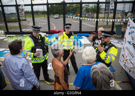 Burghfield, UK. 11. Juni 2016. Verteidigungsministerium Polizisten zu Ex-Greenham Common Frieden Aktivisten warnen, dass sie mit Vorladungen wegen Nichtumsetzung der Banner aus der Umzäunung des AWE Burghfield in Verstoß gegen einen Erlass Verbot Verunstaltung des Zauns entfernen ausgestellt werden.  Bildnachweis: Mark Kerrison/Alamy Live-Nachrichten Stockfoto