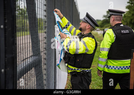 Burghfield, UK. 11. Juni 2016. Verteidigungsministerium Polizisten entfernen einen Banner hing von Ex-Greenham Common Frieden Aktivisten an der Umzäunung des AWE Burghfield in Verstoß gegen einen Erlass Verbot Verunstaltung des Zauns. Es war den fünften Tag in Folge der Blockade der Lieferungen Eingang als Teil eines Monats Klage gegen Trident Erneuerung außerhalb der Fabrik verantwortlich für die Endmontage der Trident Atomsprengköpfe montiert. Bildnachweis: Mark Kerrison/Alamy Live-Nachrichten Stockfoto