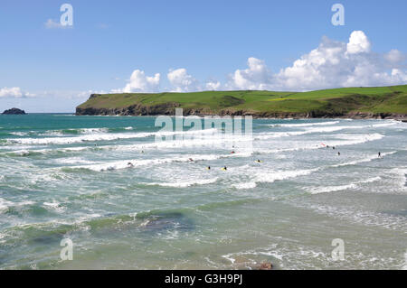 Cornwall - Polzeath Strand - wogenden eingehende Flut - weißen angeschnittene Ärmel Wellen - Surfer - Kulisse Pentire Head - blauen Meeres und des Himmels Stockfoto