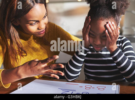 Frustrierte Kind lernt zu berechnen, Mutter und Tochter Hausaufgaben, schwarze Familie Stockfoto