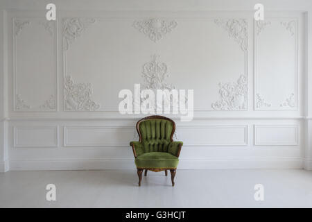 Wohnzimmer mit antiken stilvolle grüne Sessel auf Luxus weiße Wand Basrelief Stuck Zierleisten-Jahrgang Designelemente Stockfoto