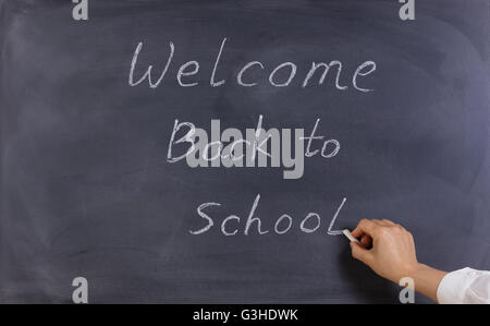 Zurück zum Schulkonzept mit Lehrerin Hand auf gelöschte schwarze Tafel zu schreiben. Stockfoto