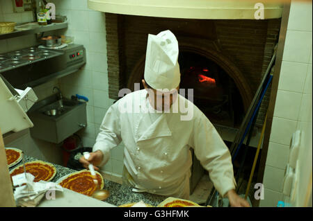 Koch, die Vorbereitung von Pizza in einem Restaurant vor dem Kochen in einem traditionellen Pizzaofen, Rom, Italien Stockfoto