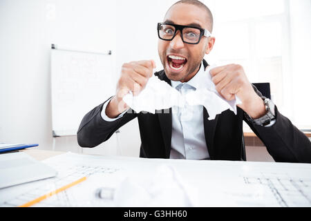 Wütend Geschäftsmann zerreißt ein Dokument, Vertrag oder Vereinbarung im Büro Stockfoto