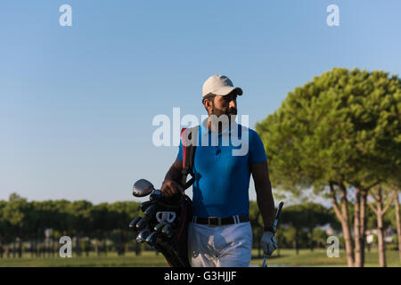 schöne orientalische Golfer Tragetasche und zu Fuß zum nächsten Loch am Golfplatz Stockfoto
