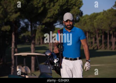 schöne orientalische Golfer Tragetasche und zu Fuß zum nächsten Loch am Golfplatz Stockfoto