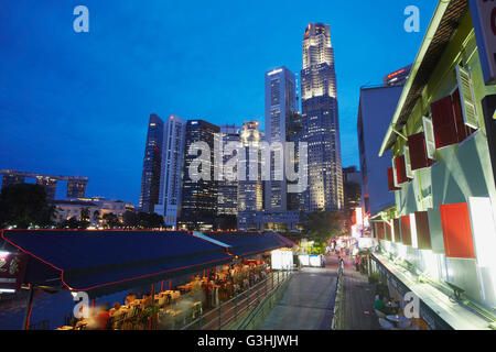 Restaurants und Bars am Boat Quay mit Wolkenkratzern des Central Business District im Hintergrund, Singapur Stockfoto