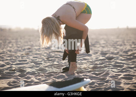 Junge Surferin Neoprenanzug anziehen, am Venice Beach, Kalifornien, USA Stockfoto