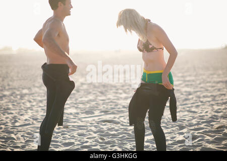 Surfen-paar anziehen Neoprenanzüge am Venice Beach, Kalifornien, USA Stockfoto