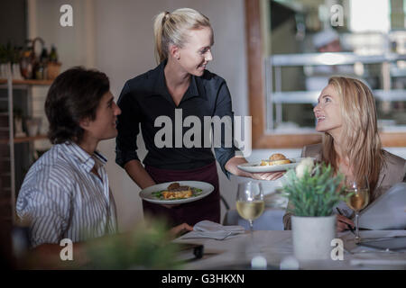 Kellnerin serviert Kunden im restaurant Stockfoto