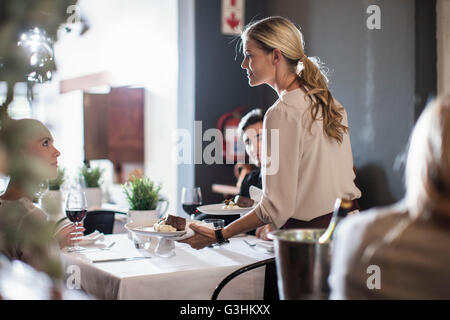 Kellnerin serviert Kunden im restaurant Stockfoto
